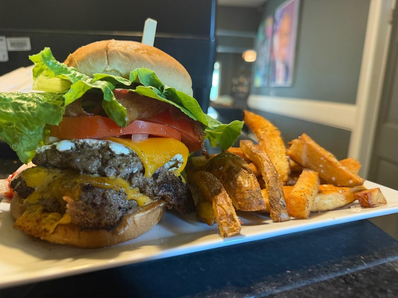 A loaded burger with melted cheese and hand-cut fries