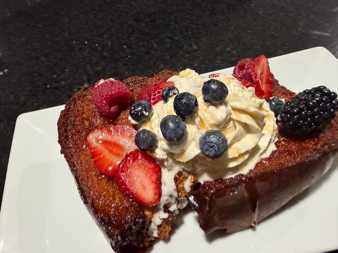 Stuffed French toast topped with fresh berries and whipped cream